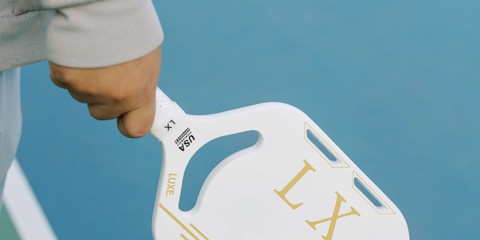 A player holding their pickleball paddle ready to receive a serve